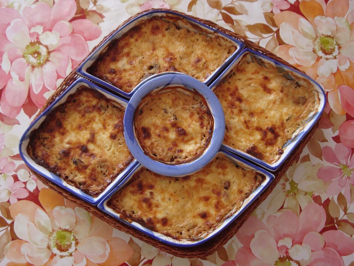 Baked chicken and cheese with a golden bubbly crust in a set of blue-rimmed serving dishes