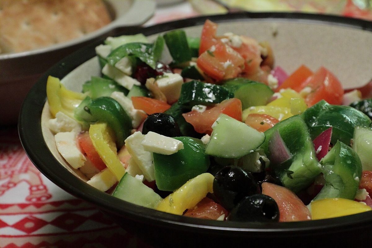 Greek salad with cucumber, tomato, peppers, black olives and feta in a bowl