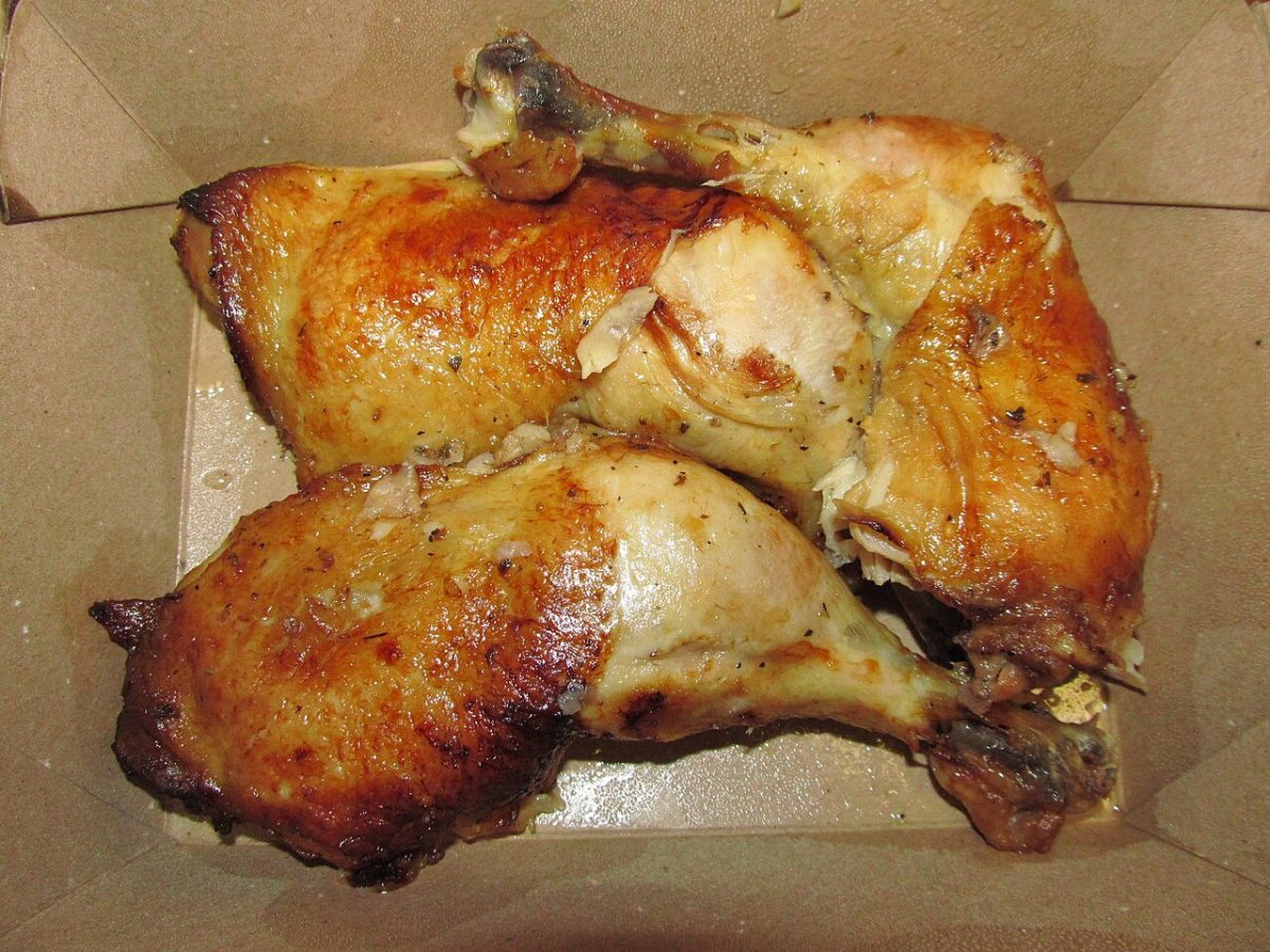 Golden roasted chicken legs and thighs sprinkled with dried herbs