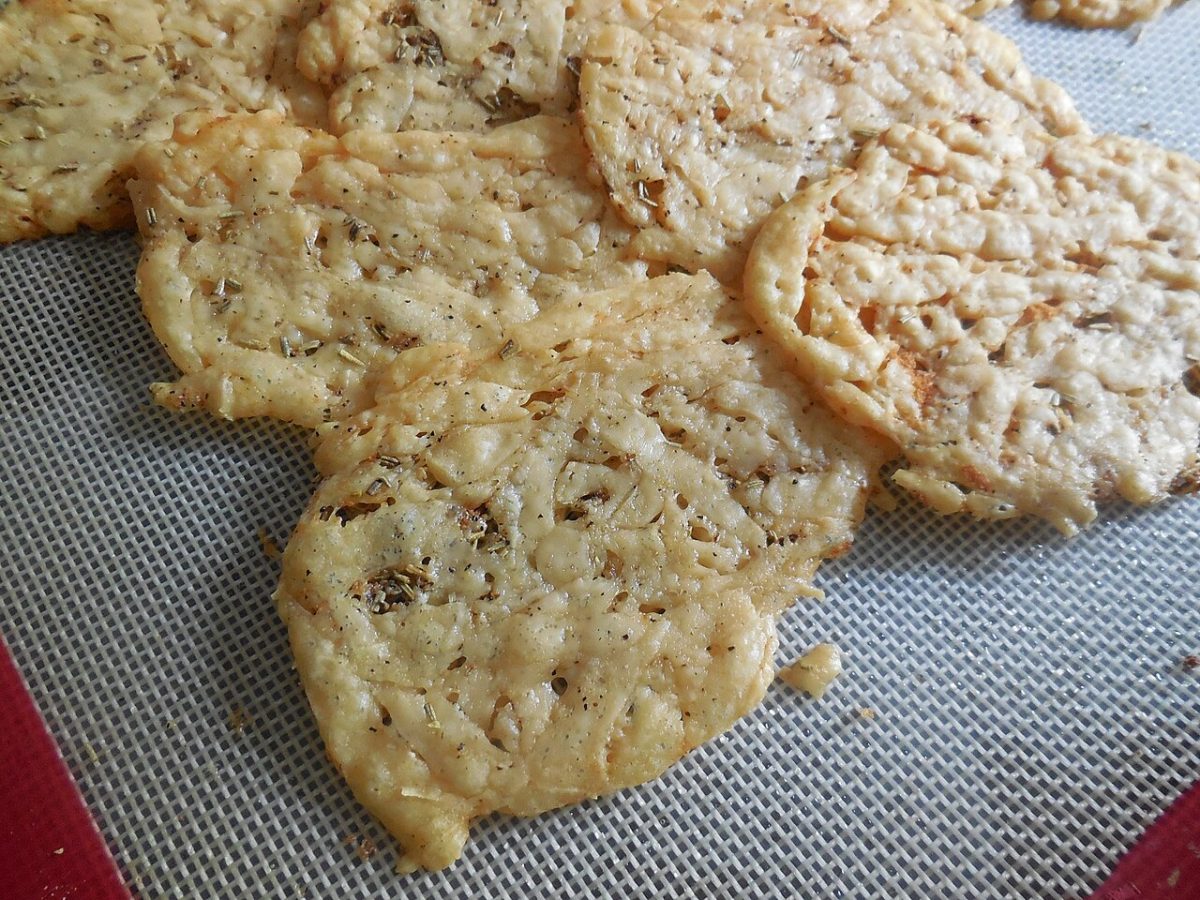 Golden baked parmesan cheese crisps on a baking mat